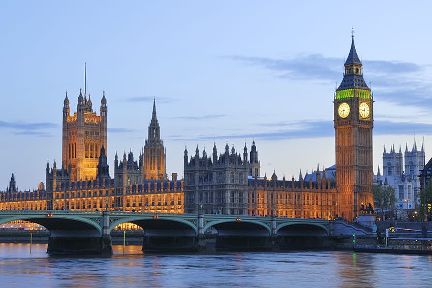 Foto nocturna con una larga exposición de las Casas del Parlamento (Palacio de Westminster), un gran edificio neogótico sobre el río Támesis
