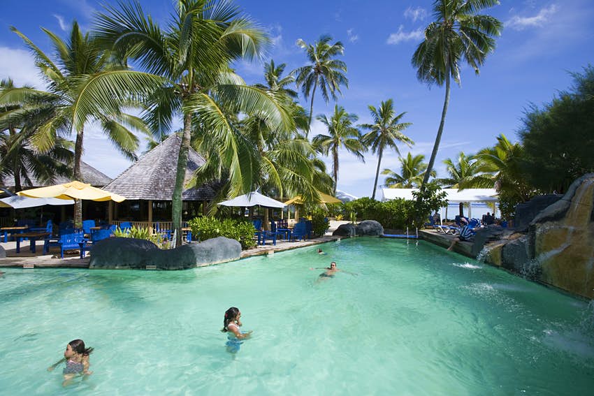 La gente nada en la piscina en Rarotongan Beach Resort en un día claro