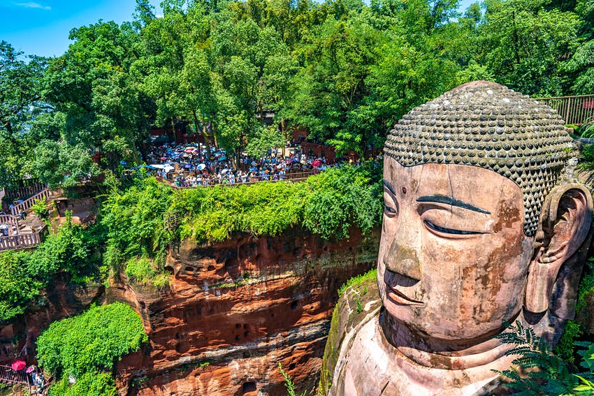 Los turistas ven la cabeza del Gran Buda en Le Shan