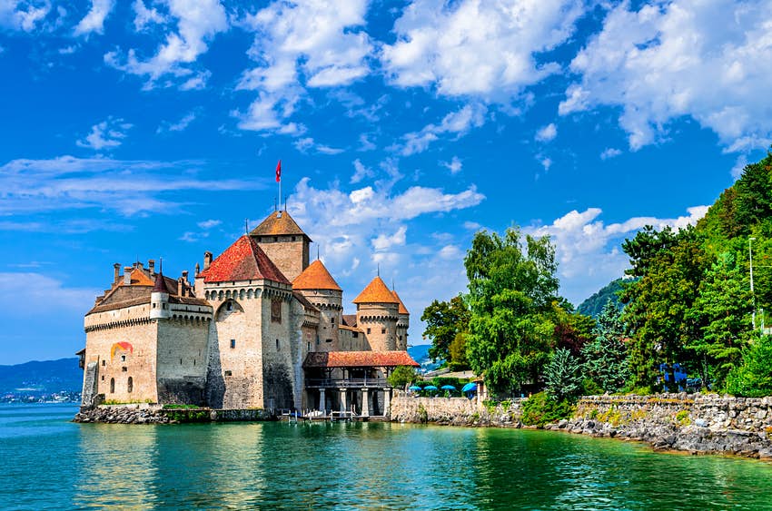 El exterior del castillo de Chilon, uno de los castillos más populares de Suiza.  El edificio se alza sobre una roca que se adentra en el lago de Ginebra y la mayoría de sus altos muros están rodeados de agua.