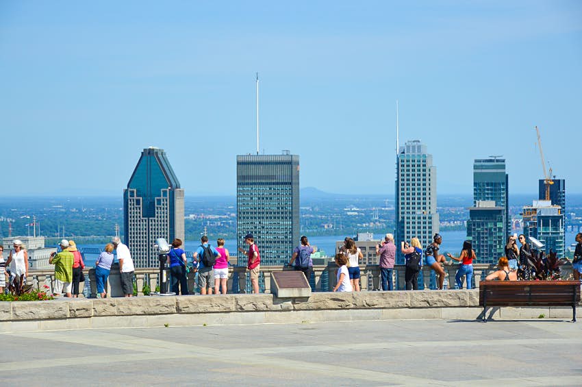 Una fila de personas a la vista, mirando la silueta de la ciudad.